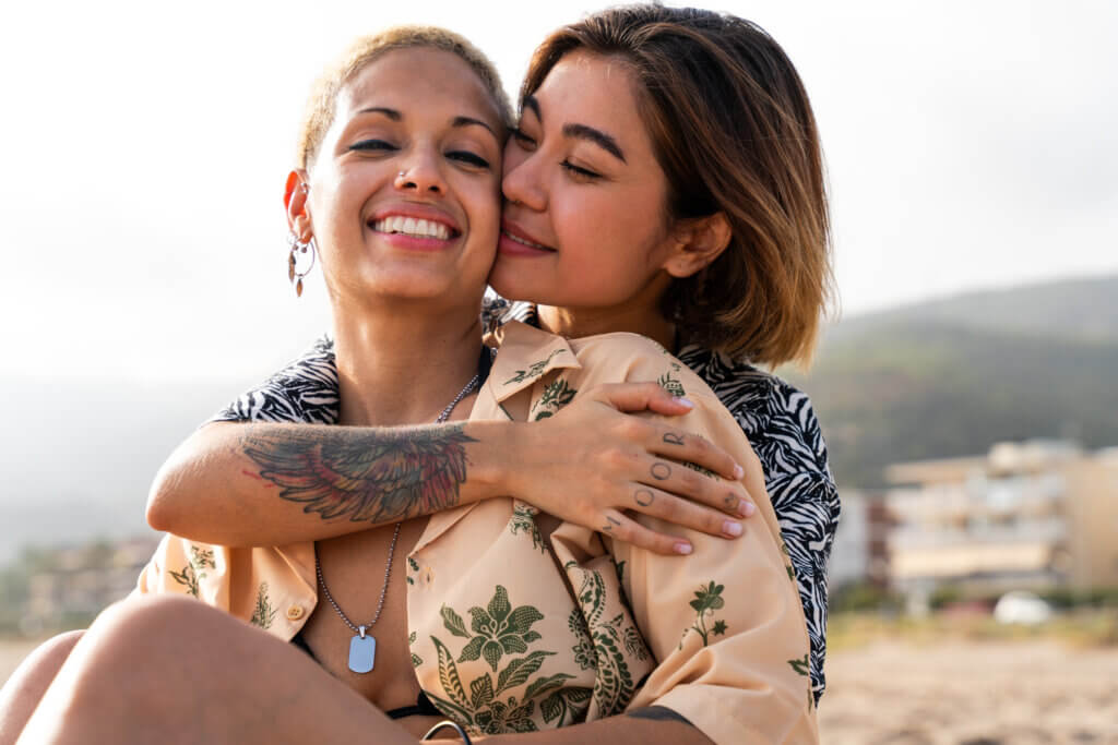 Beautiful multiethnic lesbian couple of lovers dating outdoors - LGBT people bonding and spending time together, concepts about LGBTQ community, diversity, love and lifestyle
