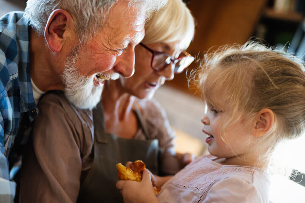 Happy smiling grandparents having fun times with children at home